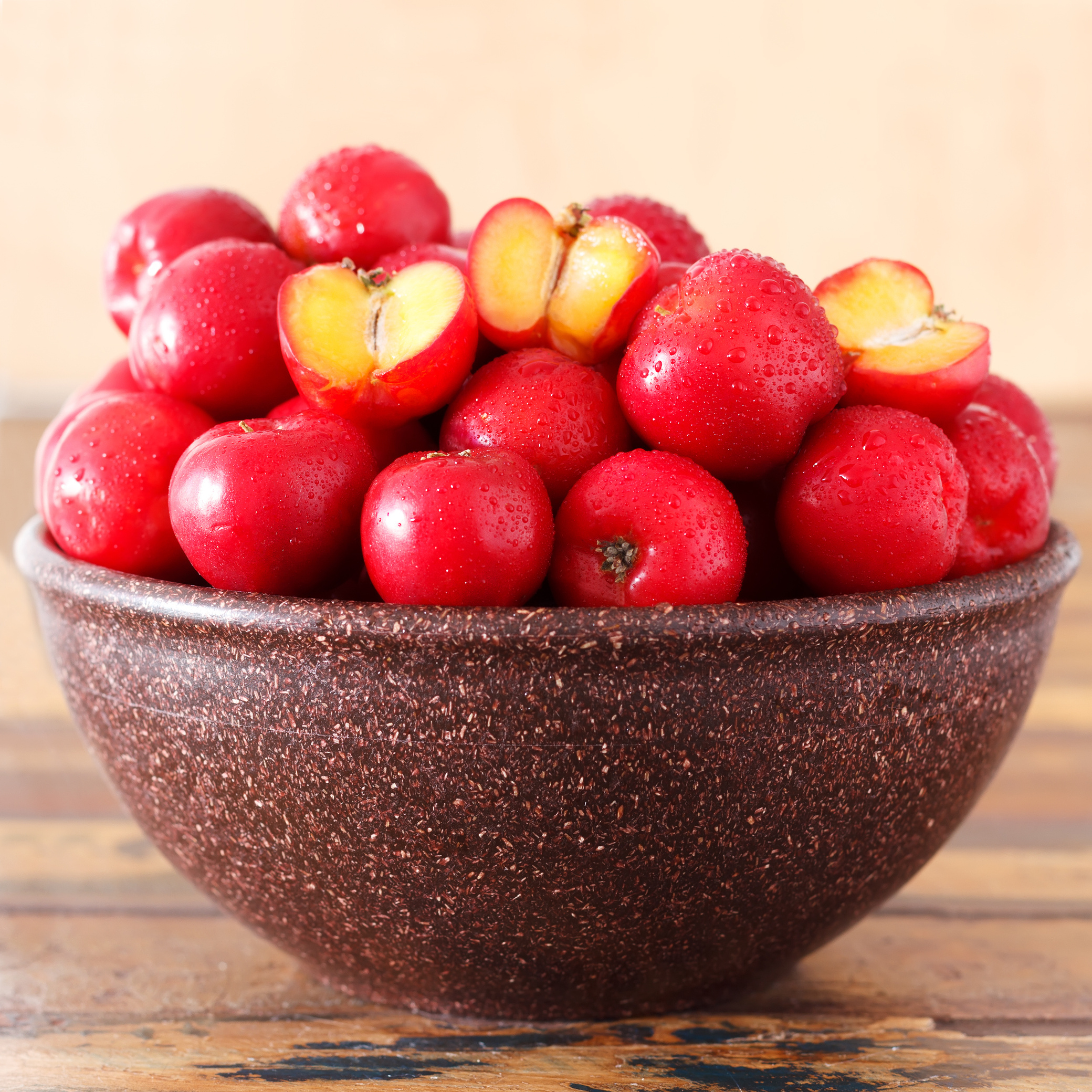 Red acerola (malpighia glabra), tropical fruit  in brown bowl